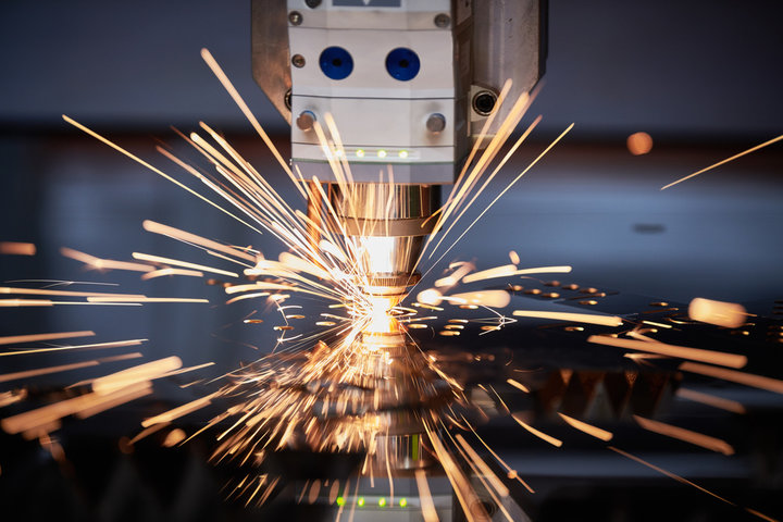 Laser cutting. Metal machining with sparks on CNC laser engraving maching